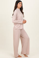 woman wearing a beige ribbed loungewear set with a high neckline and wide-leg pants