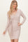 woman wearing a light beige long sleeve wrap dress with a tied waist detail