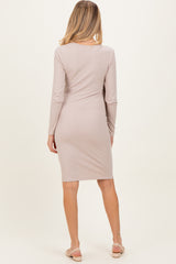 woman wearing a light taupe long sleeve maternity dress, viewed from the back