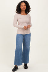 woman wearing a beige long sleeve ribbed top and wide leg blue jeans