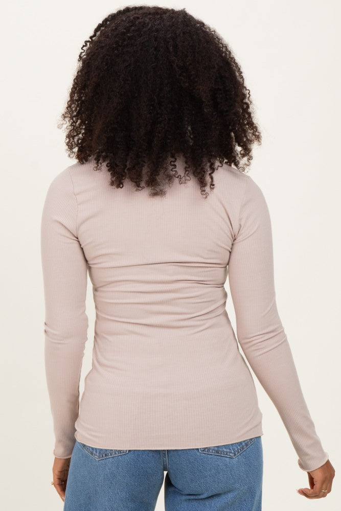woman wearing a snug light pink long sleeve ribbed top, showing the back view and styled with blue jeans