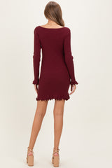woman wearing a burgundy long sleeve ribbed maternity dress with ruffled hem and sleeves