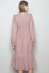 woman wearing a maroon floral long sleeve dress with ruffle details and a tiered skirt seen from the back