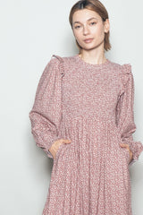 woman wearing a pink floral long sleeve dress with puffed sleeves and pockets