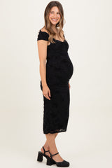 woman wearing a black off-shoulder maternity dress with ruching and a visible baby bump