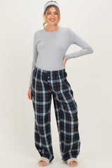 woman wearing a grey long sleeve maternity top and plaid wide-leg maternity pants with a matching headband