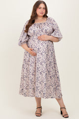 woman wearing a floral print maternity dress with puff sleeves and a baby bump, standing and smiling