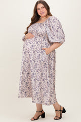 woman wearing a floral print maternity plus maxi dress with puff sleeves and pockets, showing her baby bump