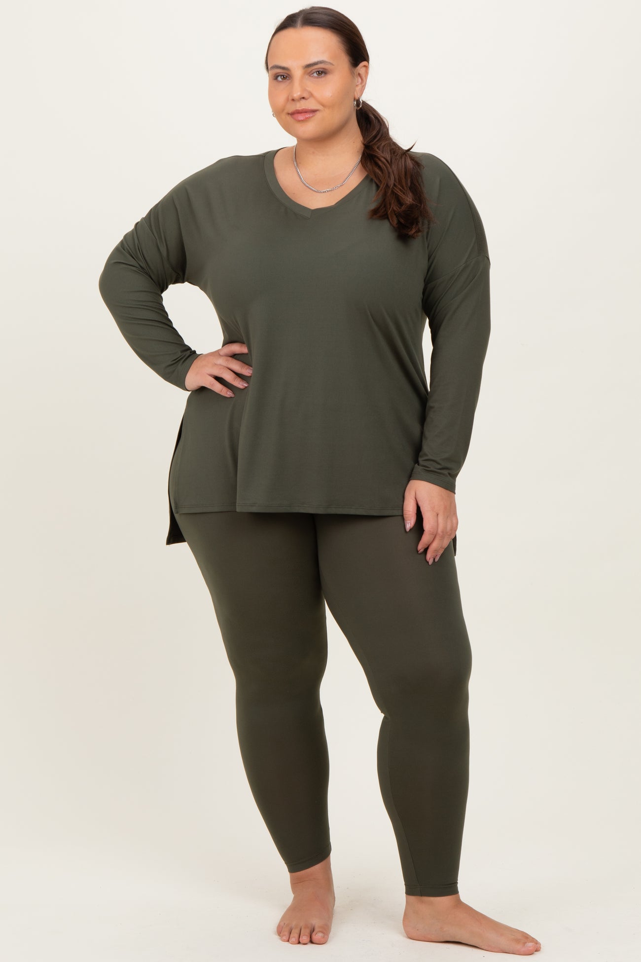 woman wearing an olive green long sleeve top and matching leggings in a plus size fit