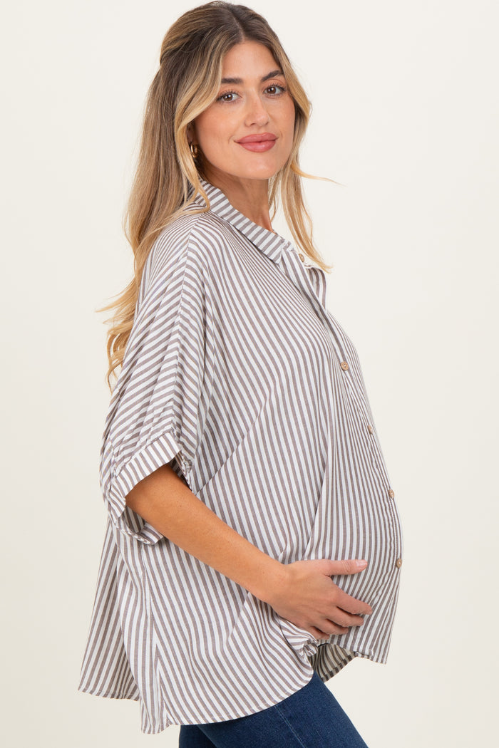 woman wearing a beige and white striped maternity shirt with a button-down front and holding her baby bump