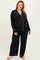 woman wearing a black maternity plus pajama set with white trim and a visible baby bump