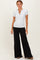 woman wearing a gray short sleeve henley top and black wide-leg pants