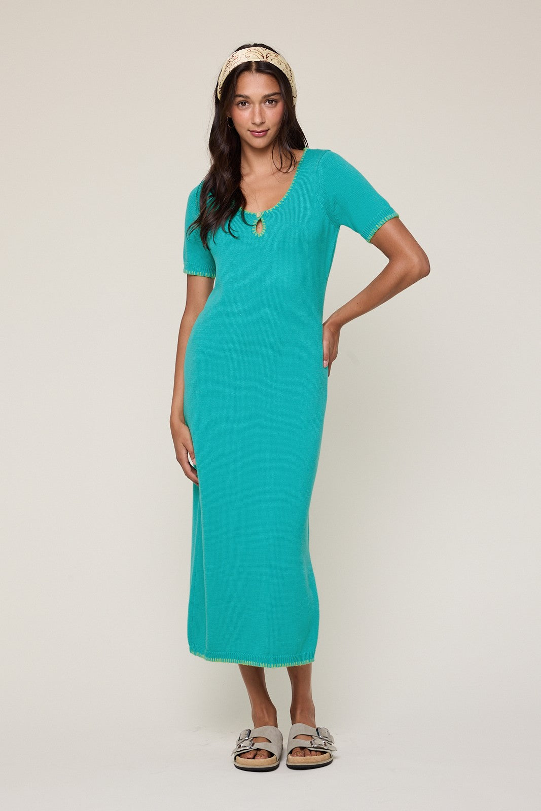 woman wearing a turquoise ribbed midi dress with short sleeves and crochet trim details