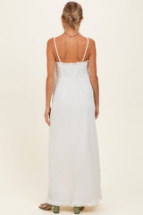 woman wearing a white maternity maxi dress with thin straps and a relaxed fit, showing a baby bump