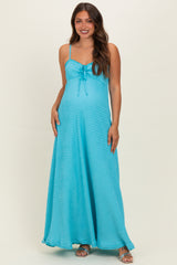 woman wearing a turquoise maternity maxi dress with a tie detail and a visible baby bump
