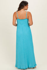 woman wearing a light blue maternity maxi dress with a smocked back and adjustable spaghetti straps