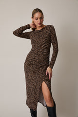 woman wearing a brown long sleeve midi dress with a patterned design and a side slit