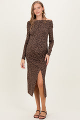 woman wearing a brown polka dot off-the-shoulder maternity dress with a side slit and a visible baby bump
