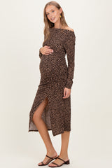 woman wearing a brown off-shoulder maternity dress with polka dots and a side slit, showing her baby bump