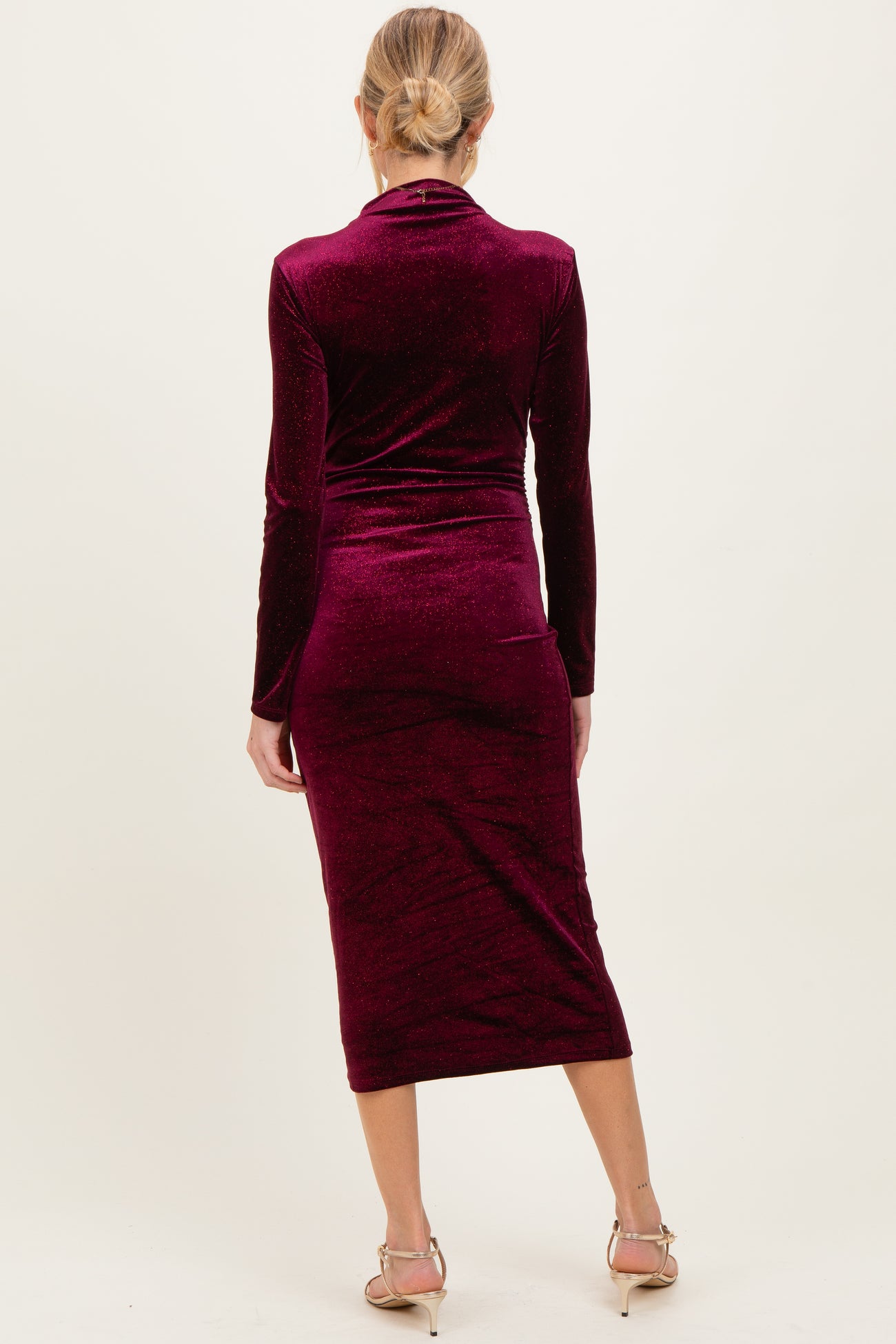 woman wearing a burgundy long sleeve maternity dress with a bodycon fit and mid-calf length