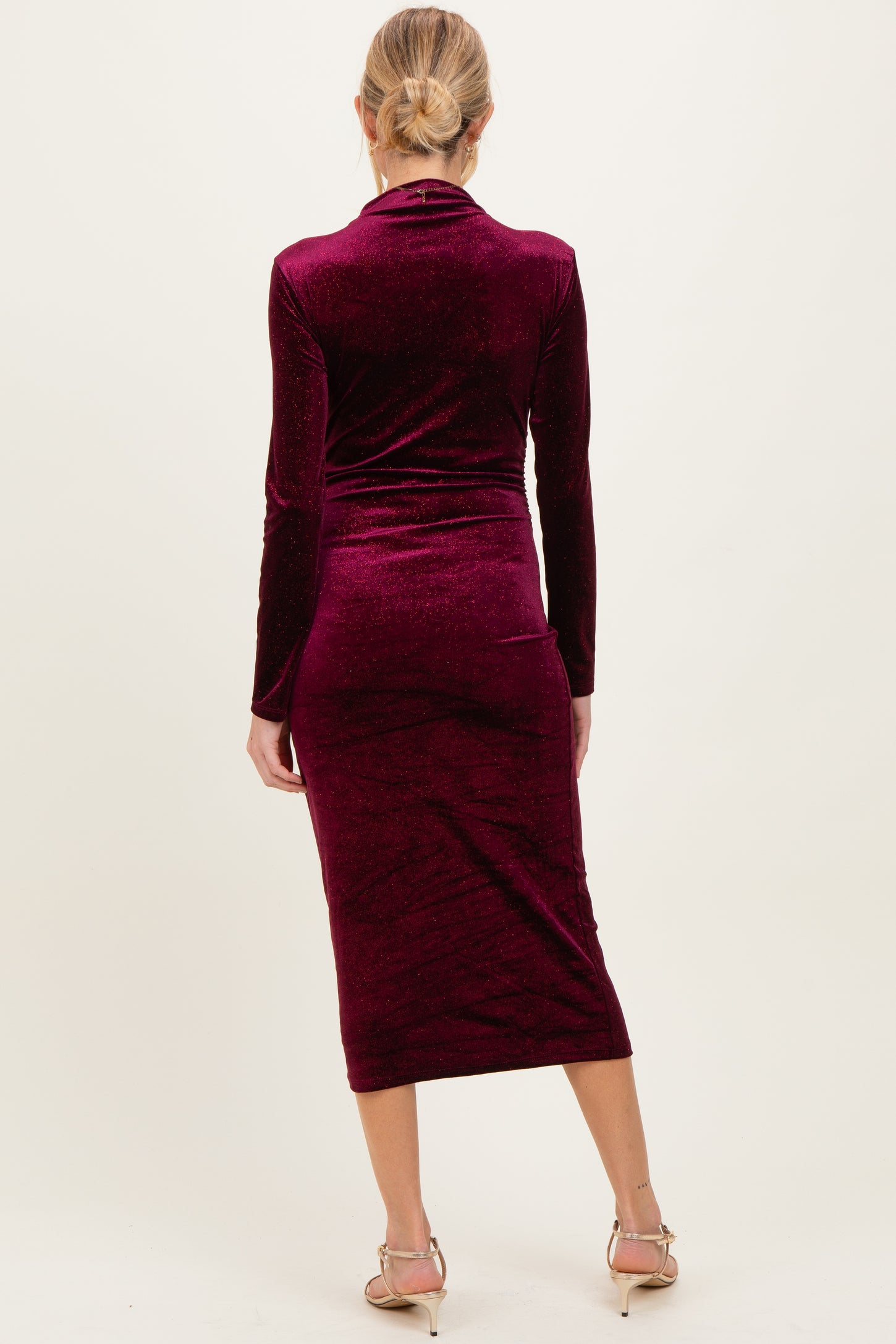 woman wearing a burgundy long sleeve maternity dress with a bodycon fit and mid-calf length
