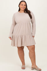 woman wearing a beige long sleeve ribbed plus size dress with a tiered skirt and a relaxed fit