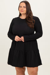 woman wearing a black long sleeve plus size dress with a tiered skirt and ribbed texture