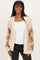 woman wearing a cream knitted cardigan with floral lace sleeves over a white top and black jeans