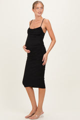 woman wearing a black sparkly maternity dress with adjustable straps and a fitted silhouette, highlighting her baby bump
