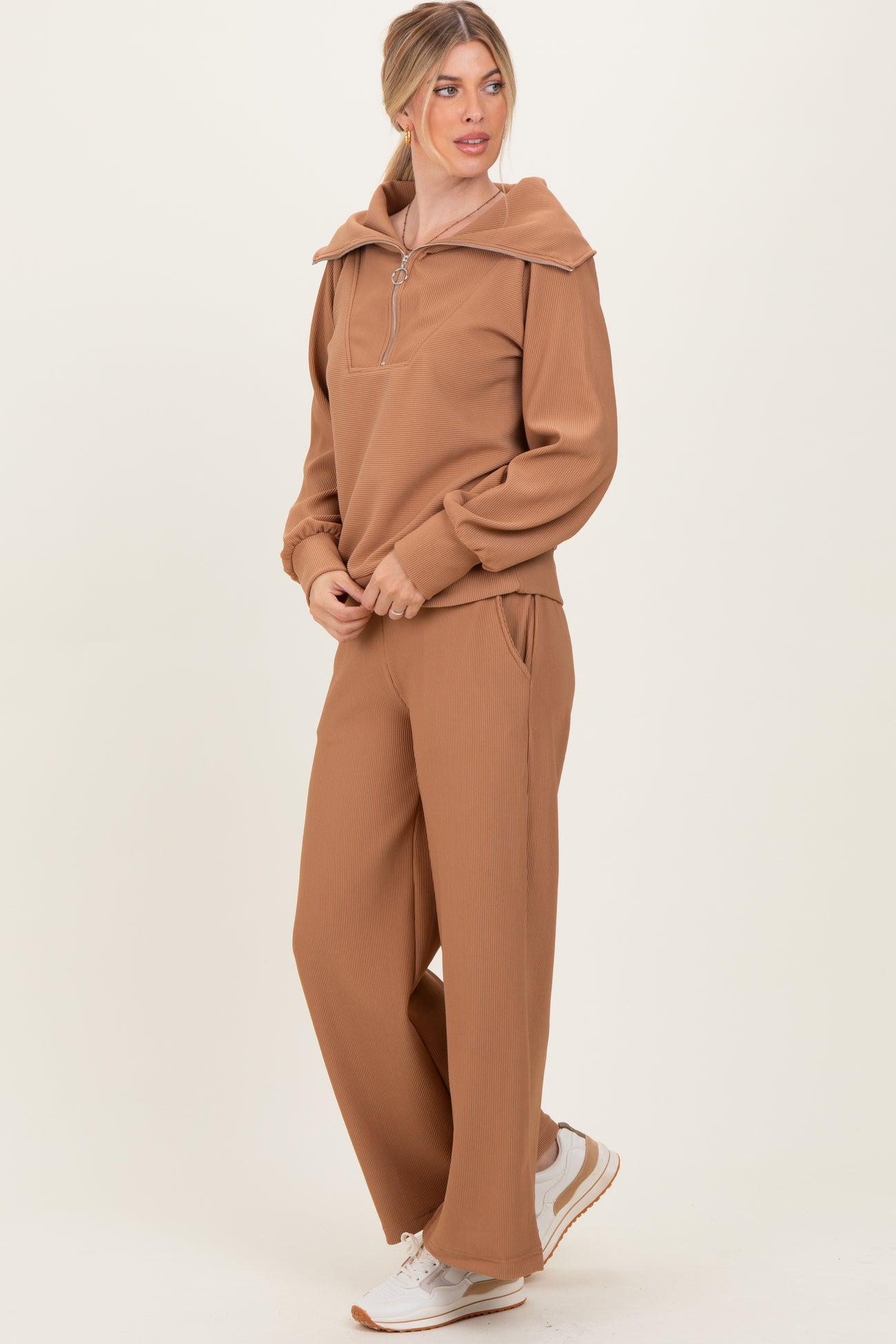 woman wearing a brown ribbed two-piece loungewear set with a zip-up hoodie and wide-leg pants