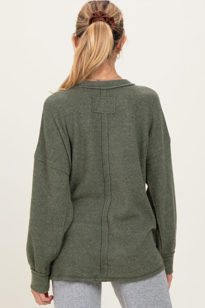 woman wearing a green maternity sweater with a relaxed fit and dropped shoulders, seen from the back