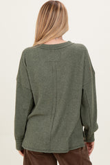 woman wearing a relaxed fit olive green long sleeve sweater with a back seam detail