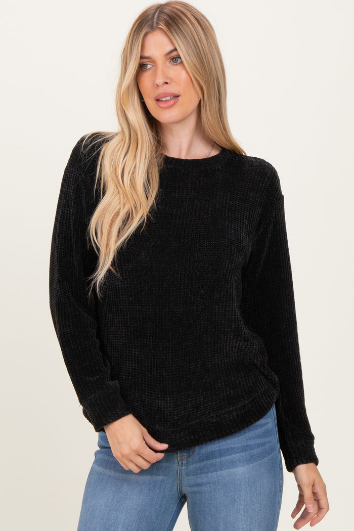 woman wearing a black ribbed long sleeve sweater and blue jeans