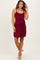 woman wearing a burgundy maternity dress with spaghetti straps and a fitted silhouette, showcasing her baby bump