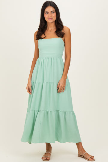 woman wearing a mint green tiered maxi dress with a strapless design and a relaxed fit
