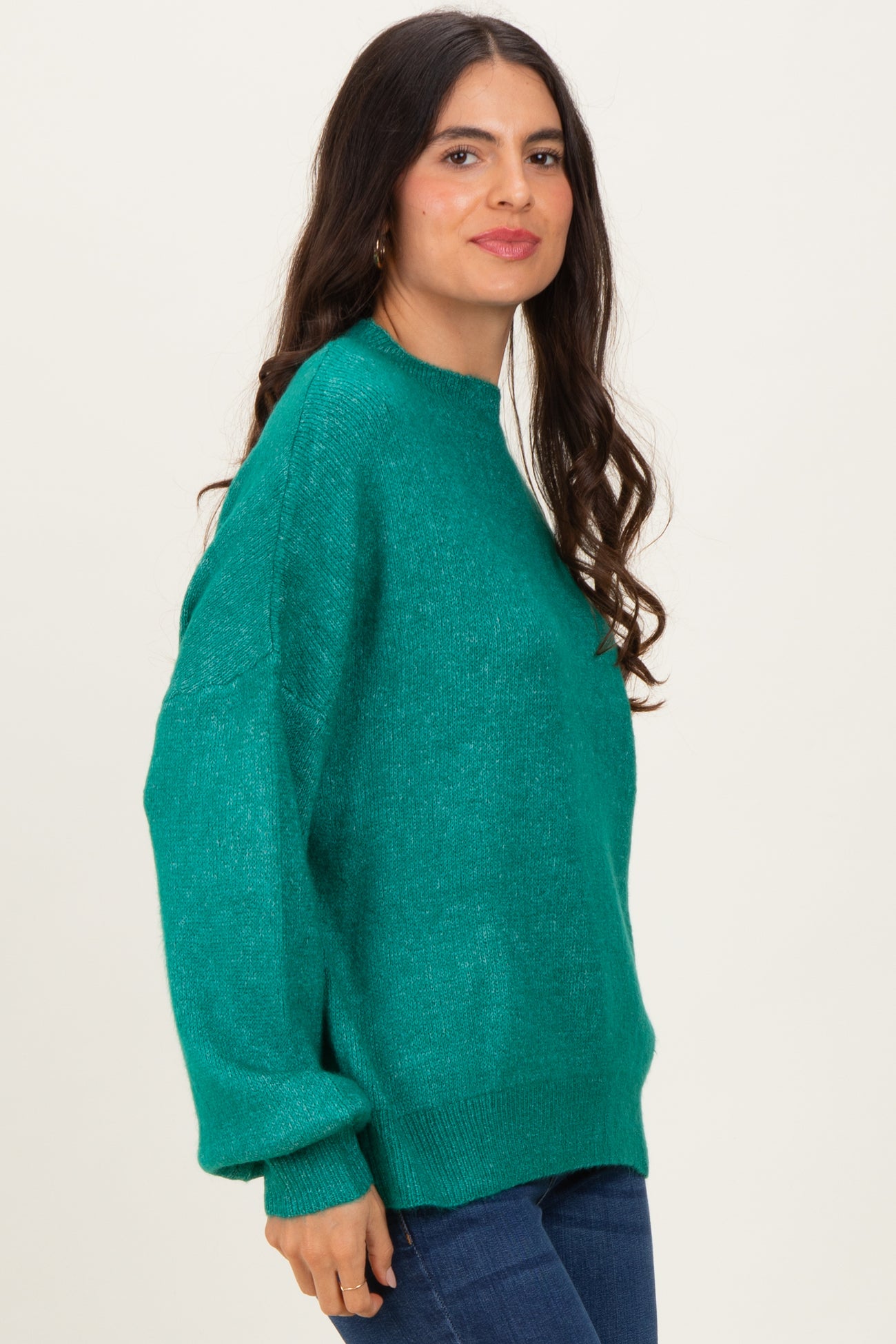 woman wearing a green oversized sweater with a crew neck and long sleeves, styled casually with jeans