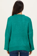 woman wearing a green oversized sweater with a relaxed fit and long sleeves, viewed from the back