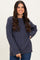 woman wearing a dark blue cable knit sweater with a relaxed fit and long sleeves, smiling at the camera