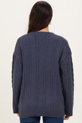 woman wearing a dark blue cable knit sweater with a relaxed fit and long sleeves, viewed from the back