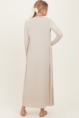 woman wearing a long beige ribbed dress with long sleeves, shown from the back