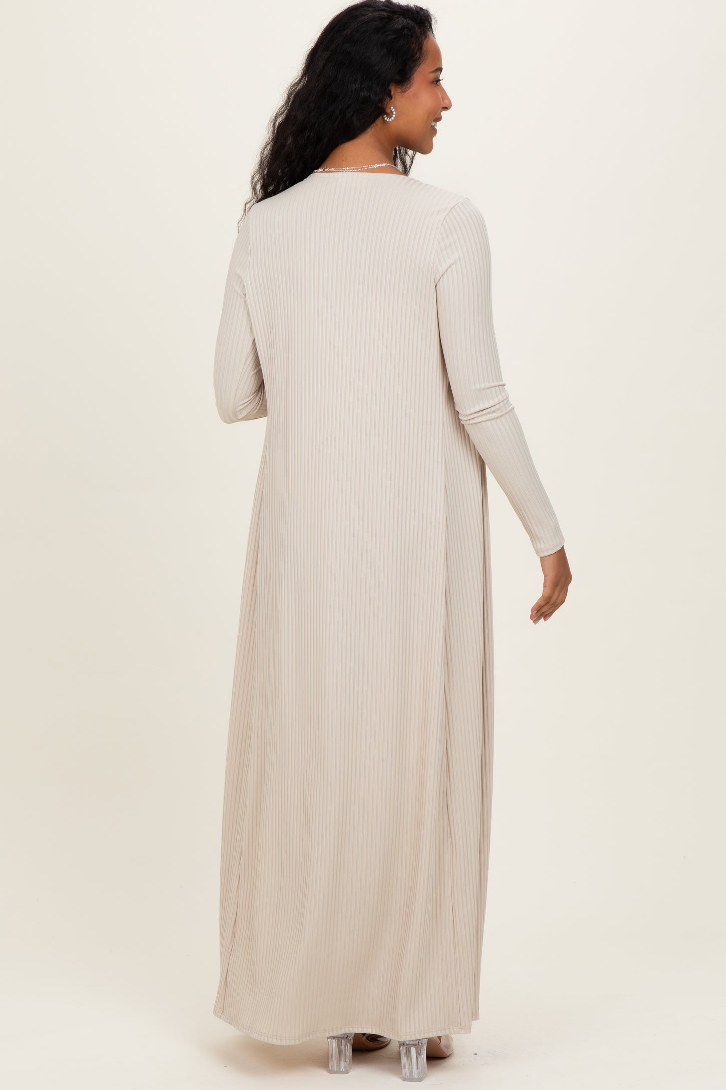woman wearing a long beige ribbed maternity dress with long sleeves, showing the back view
