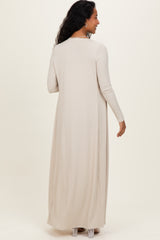 woman wearing a long beige ribbed maternity dress with long sleeves, showing the back view