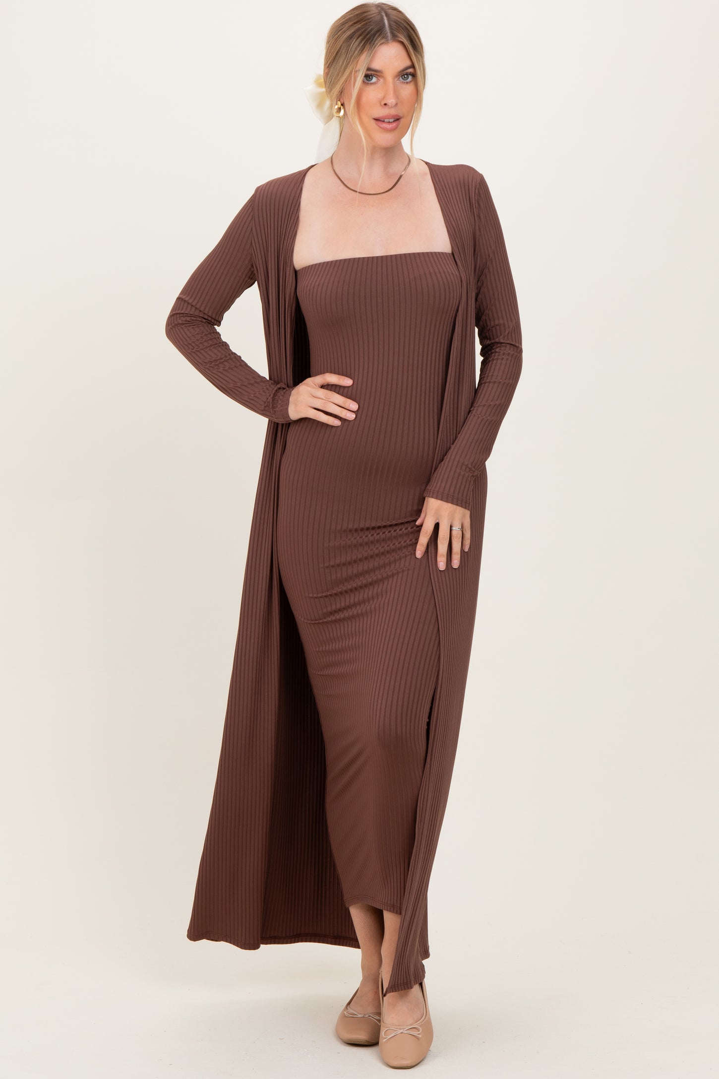 woman wearing a brown ribbed strapless maxi dress with a long cardigan and nude flats