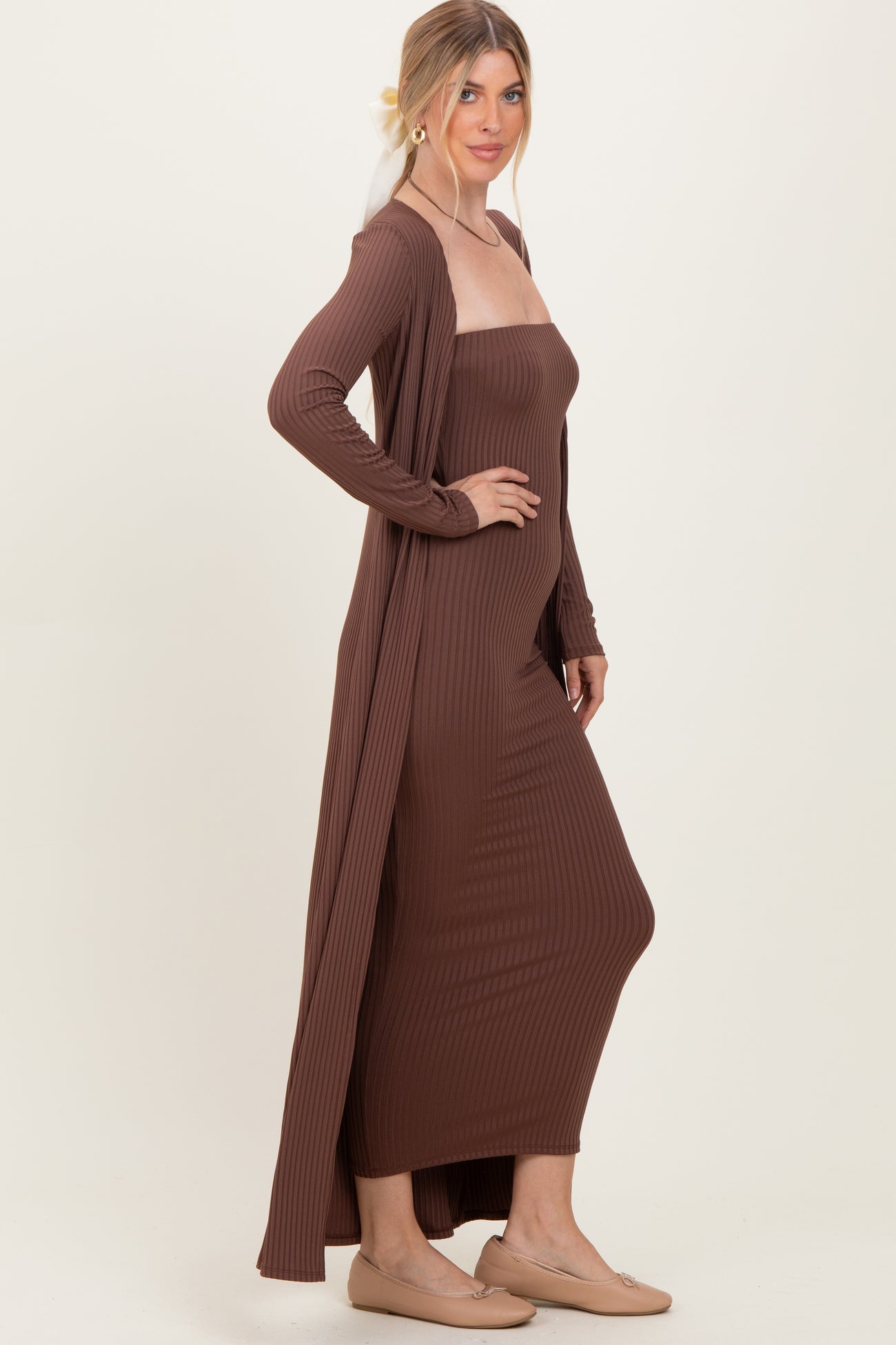 woman wearing a brown ribbed maxi dress with a long cardigan, styled with a relaxed fit and simple slip-on shoes