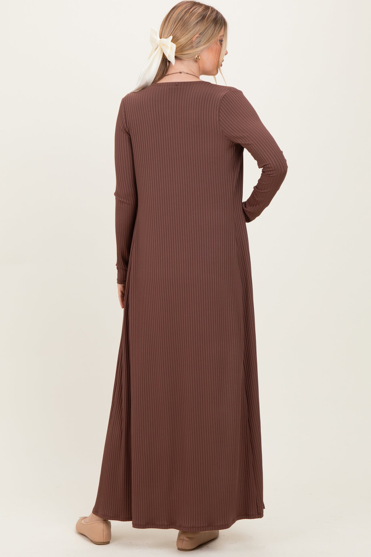 woman wearing a chocolate brown ribbed long sleeve maxi dress with a flowing silhouette from the back