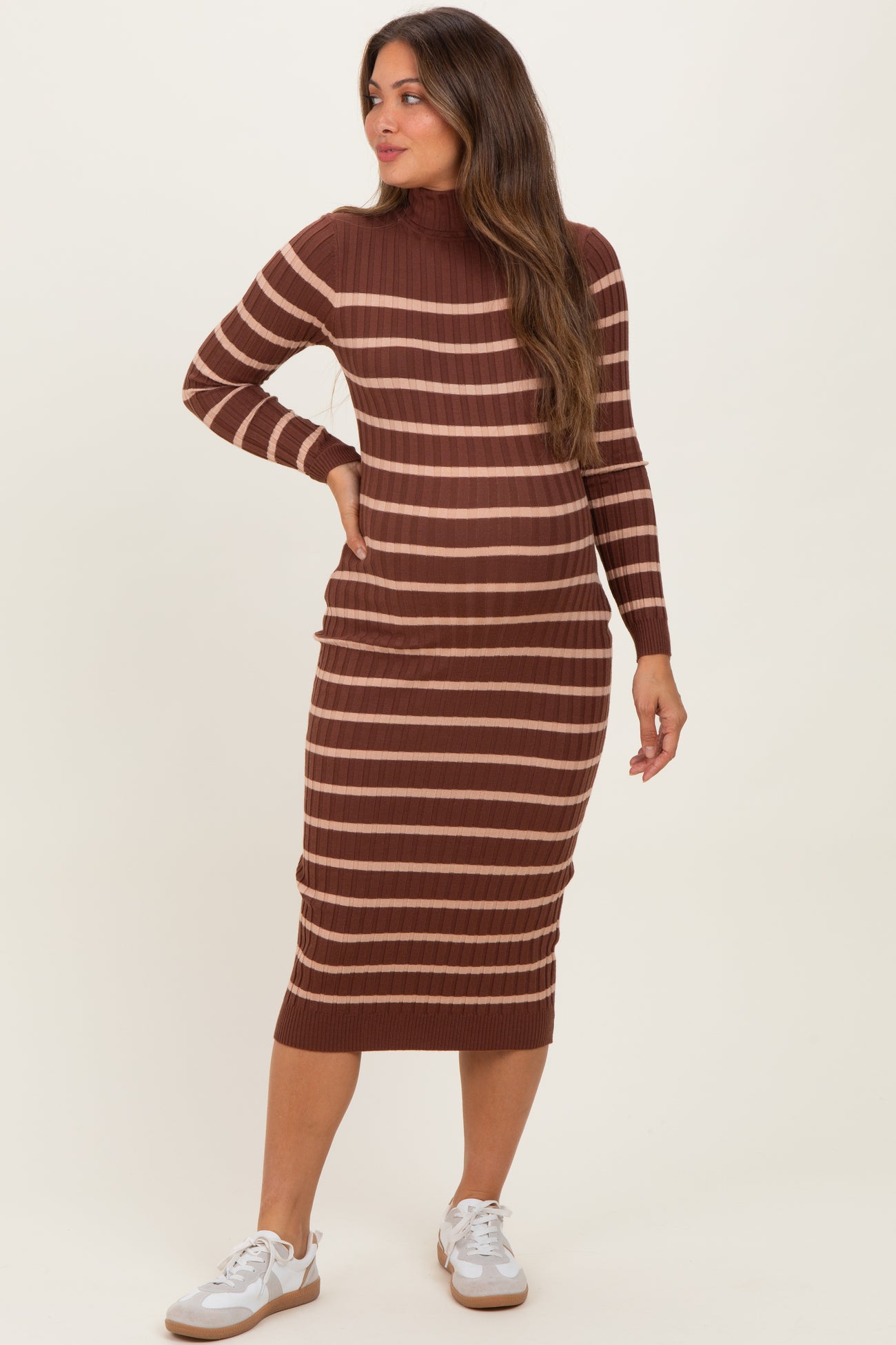woman wearing a brown and striped long sleeve maternity dress with a fitted silhouette and relaxed fit