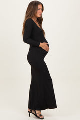 woman wearing a black long sleeve maternity dress with a fitted silhouette and visible baby bump