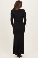 woman wearing a black long sleeve maternity maxi dress, showcasing a fitted style and back view
