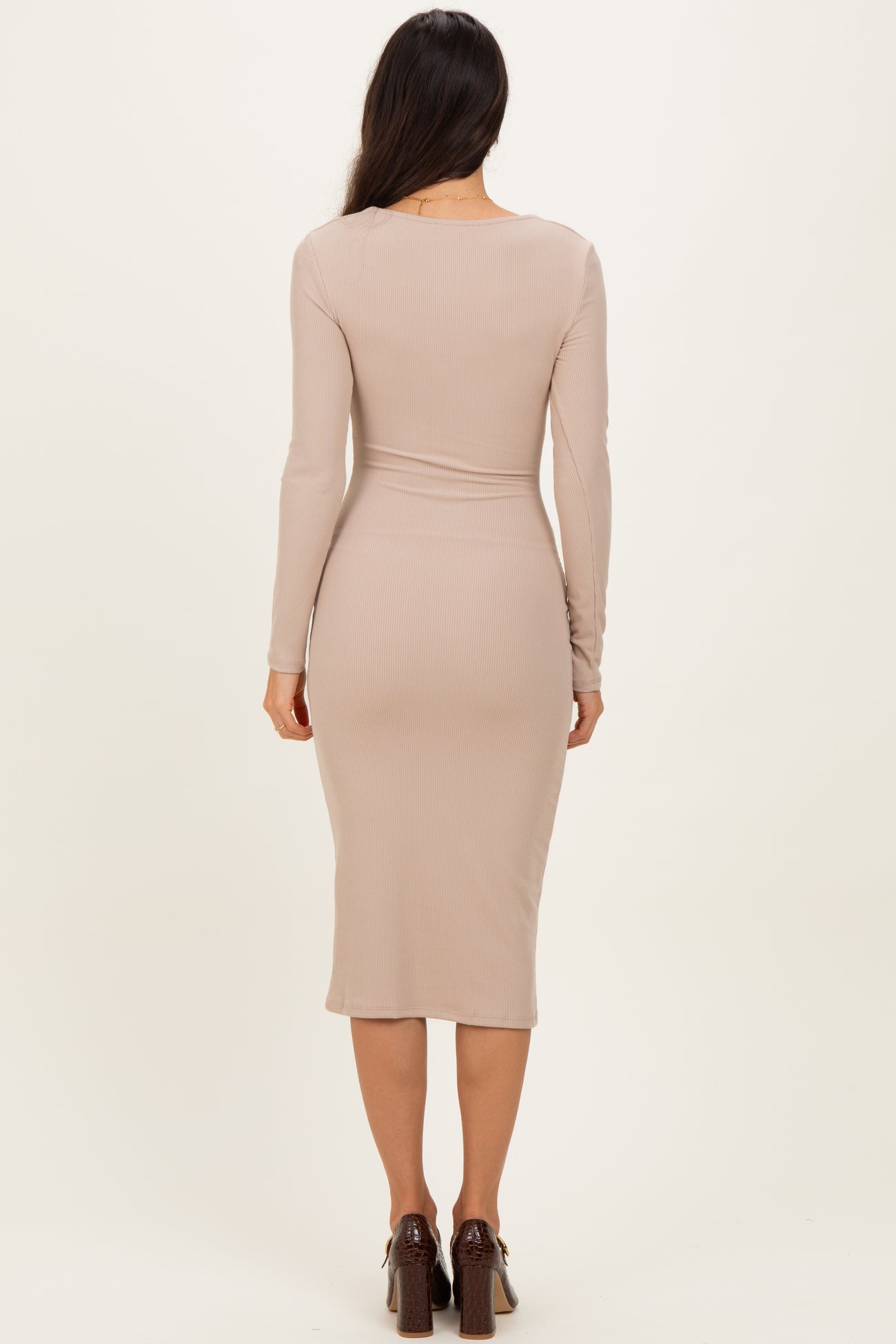 woman wearing a beige long sleeve fitted midi dress seen from the back