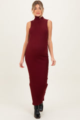 woman wearing a burgundy ribbed knit sleeveless maternity dress with a high neckline and a fitted silhouette, showcasing her baby bump
